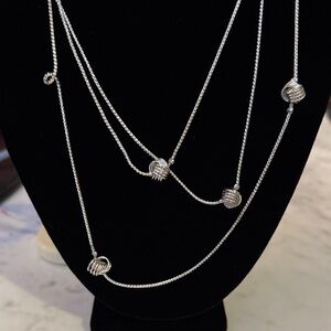 Long silver colored necklace.